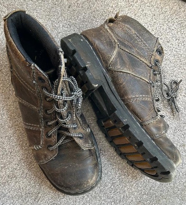 Worn Dr. Marten boots before professional resoling and repair.